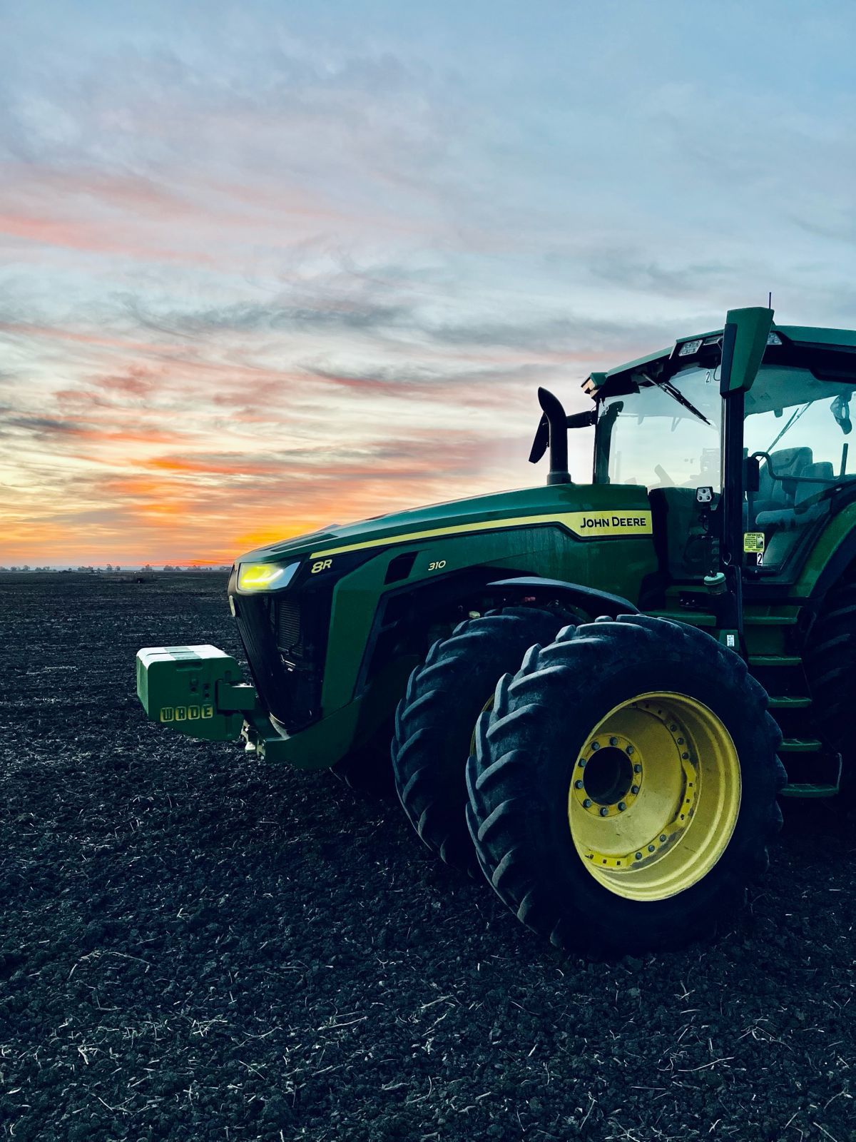 Tractor in a field at sunset